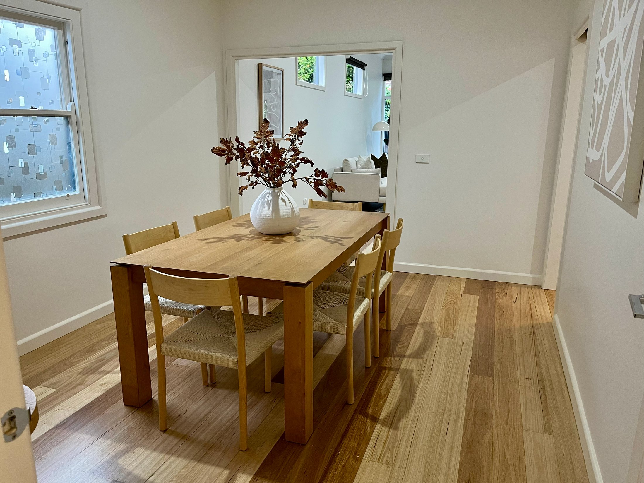 Completed dining room in the Newport home with repainted walls and cornices over restored hardwood floors