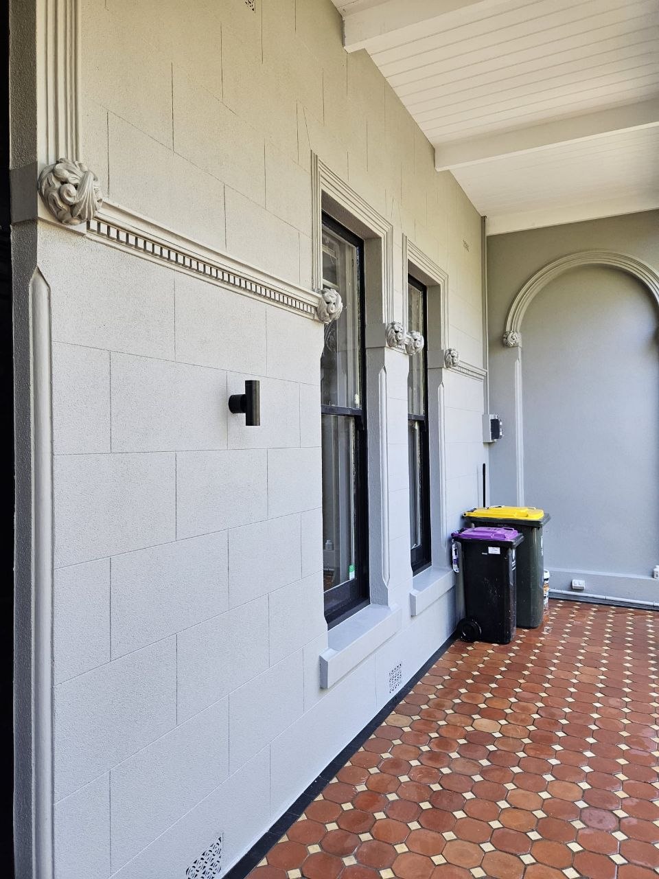 Heritage block-finish render with lion-head corbels and window mouldings, Melbourne VIC
