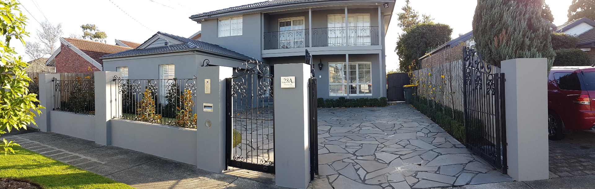 Rendered front fence, pillars and two-storey facade with decorative ironwork, Melbourne VIC