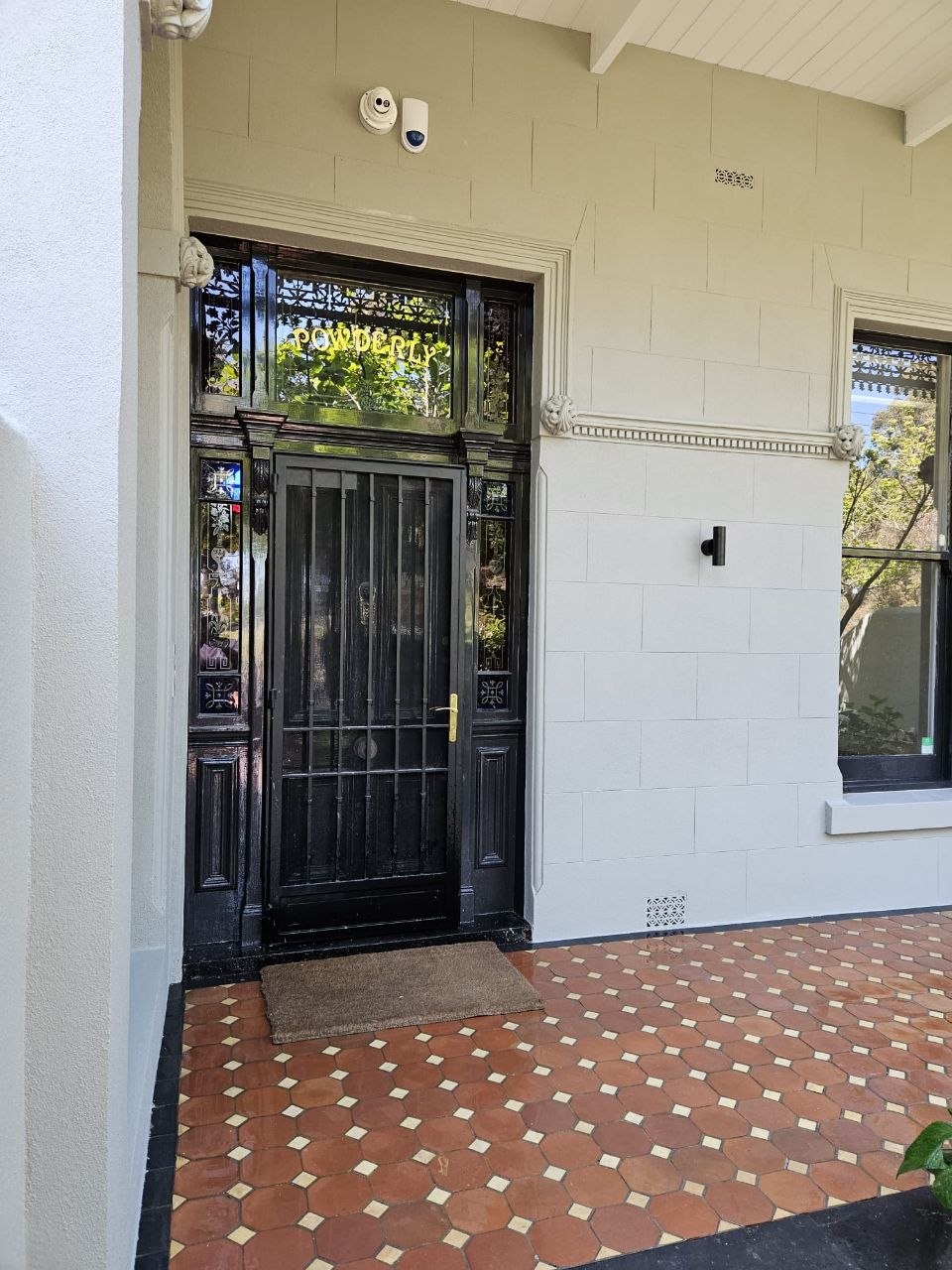 Heritage terrace front door with restored block render and POWDERLY transom, Melbourne VIC