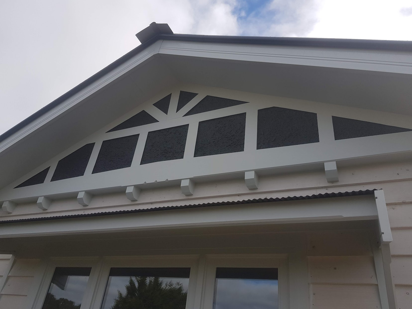 Rough cast stucco gable feature with white timber battens on weatherboard home, Melbourne VIC