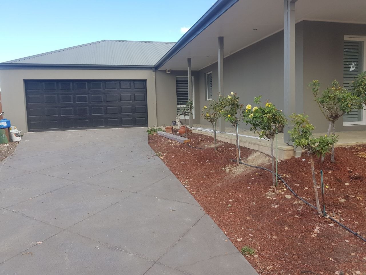 Grey rendered home with double garage and front portico, Melbourne VIC