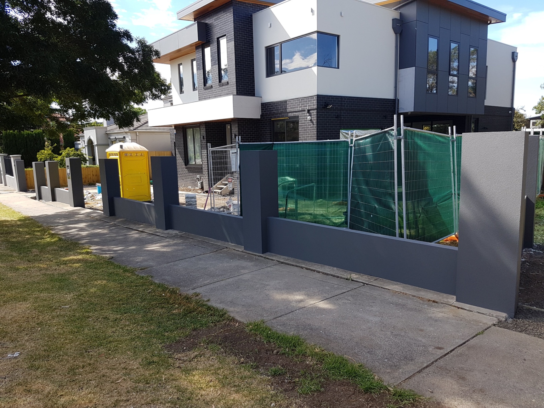 Rendered front fence and townhouse facade with contrasting dark feature panels, Melbourne VIC