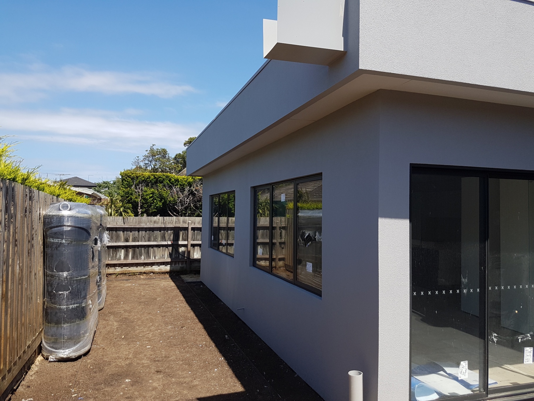Side elevation of modern rendered extension with crisp parapet and window reveals, Melbourne VIC