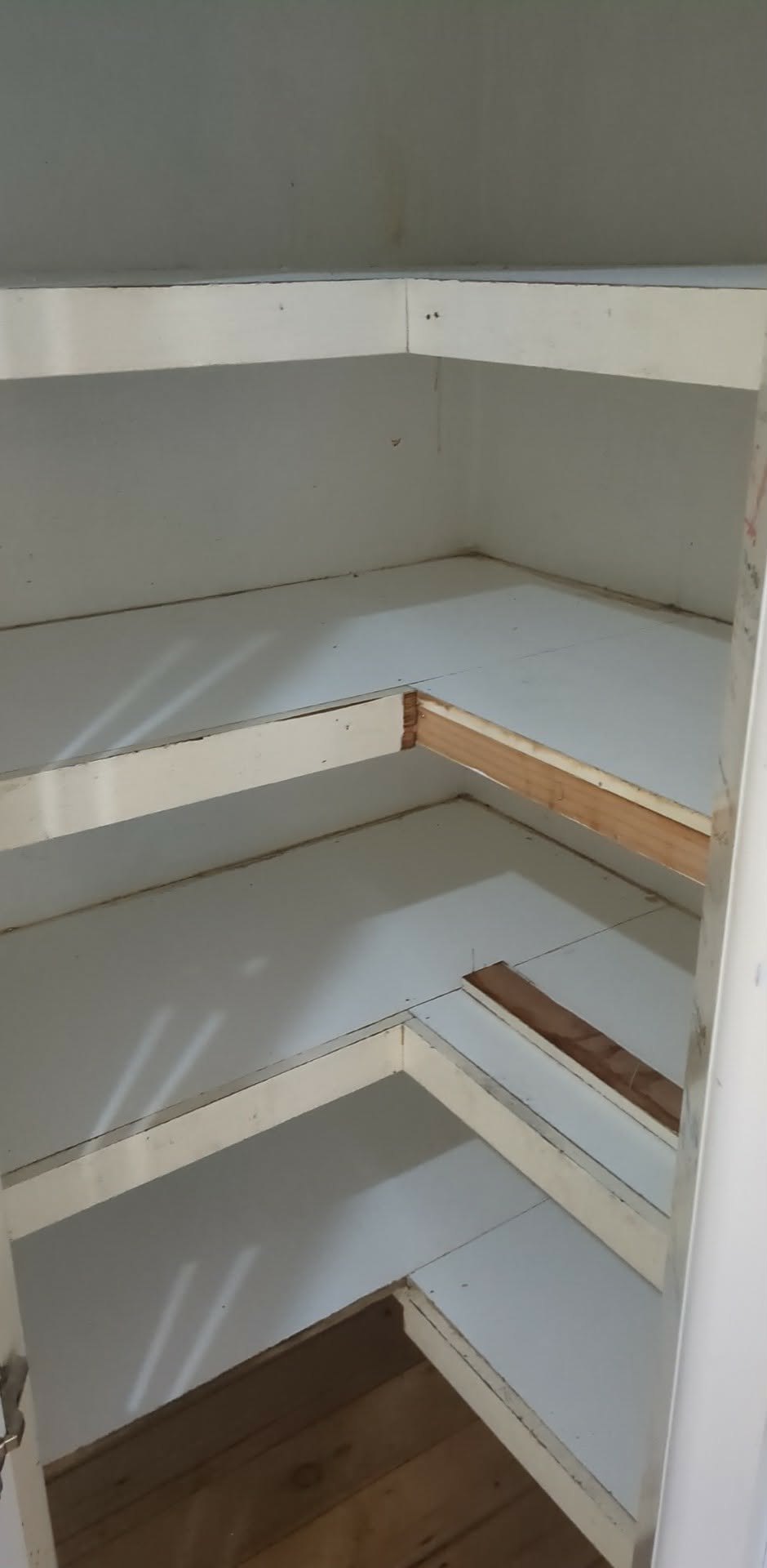 Corner shelving and wall surfaces prepared for plaster repair before painting