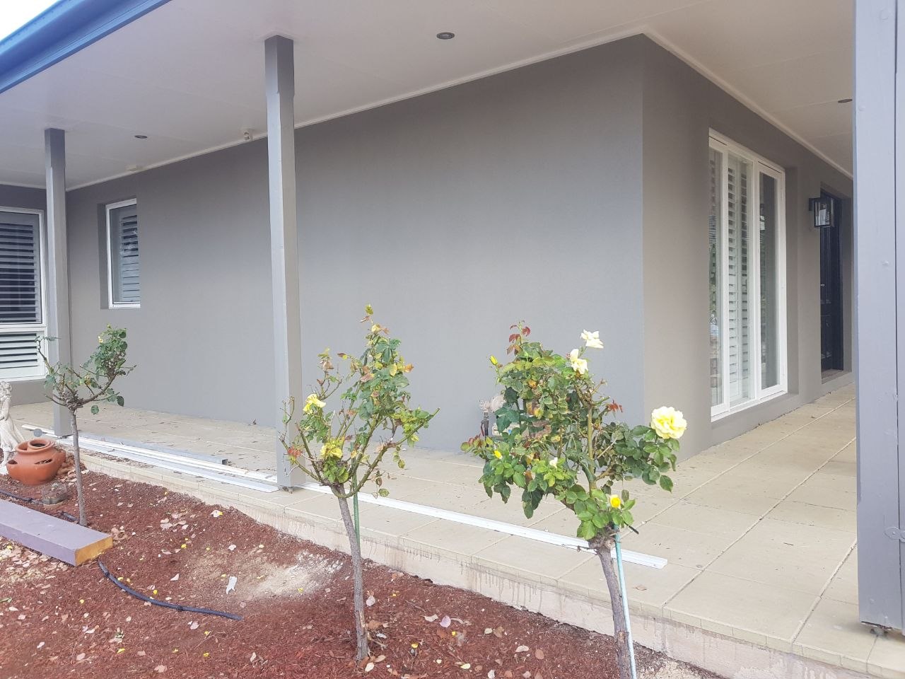 Smooth grey acrylic render on verandah walls with rose garden, Melbourne VIC